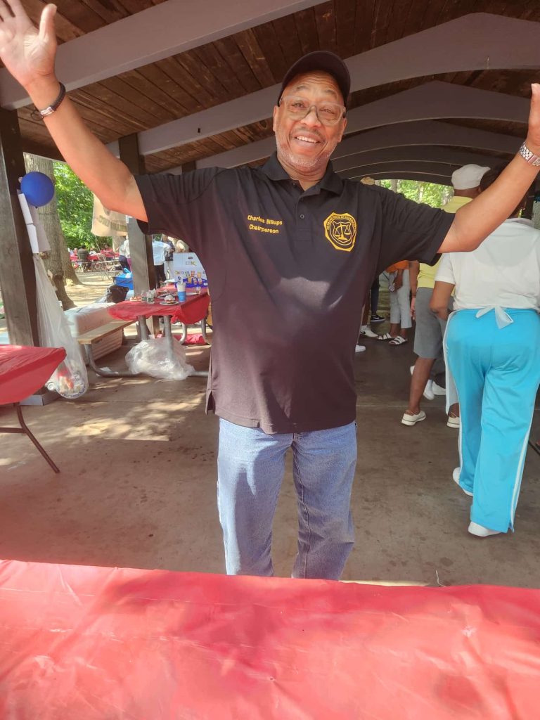 11th annual outing man with hand raised in celebration.